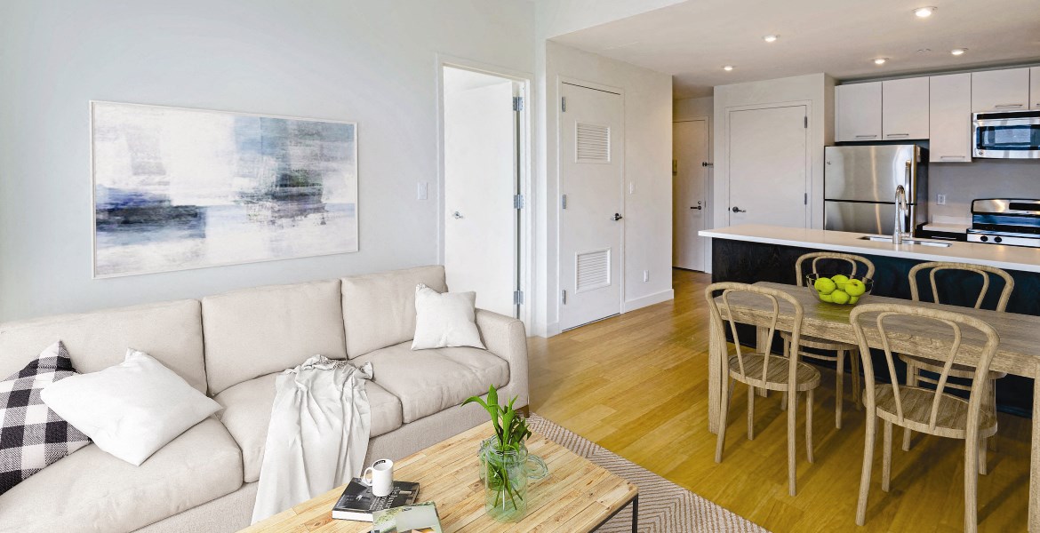 a living room and kitchen with a couch and a table